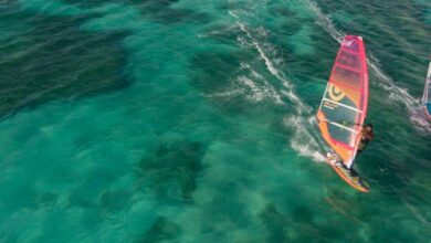 Instructor teaching a tourist basic windsurfing techniques on Aruba beach