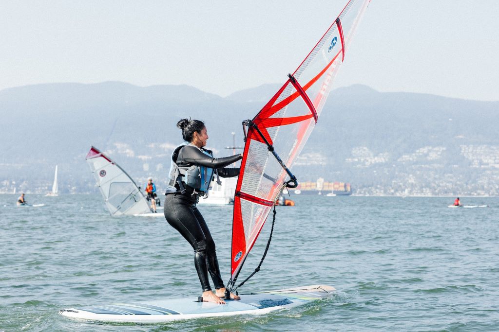 Windsurfer gearing up with board and sail on a sunny beach ready for adventure